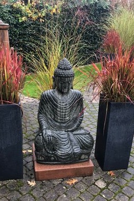 Steinfigur Buddha LUKOYANG SKULPTUREN. Perfekt platziert auf einem Steinsockel zwischen japanischen Blutgras Sträuchern