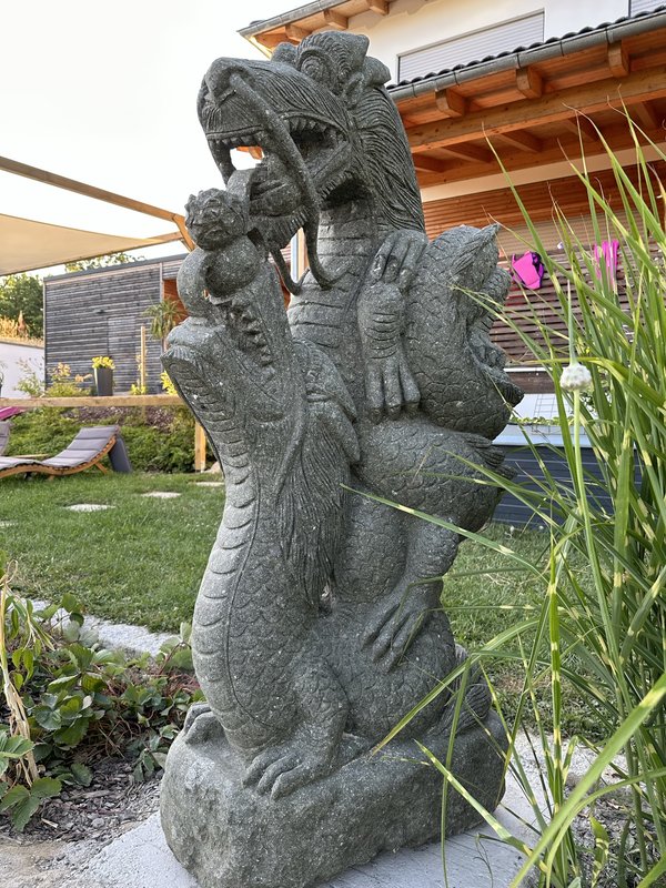Krafttier Drachen Skulptur perfekt im Garten platziert.